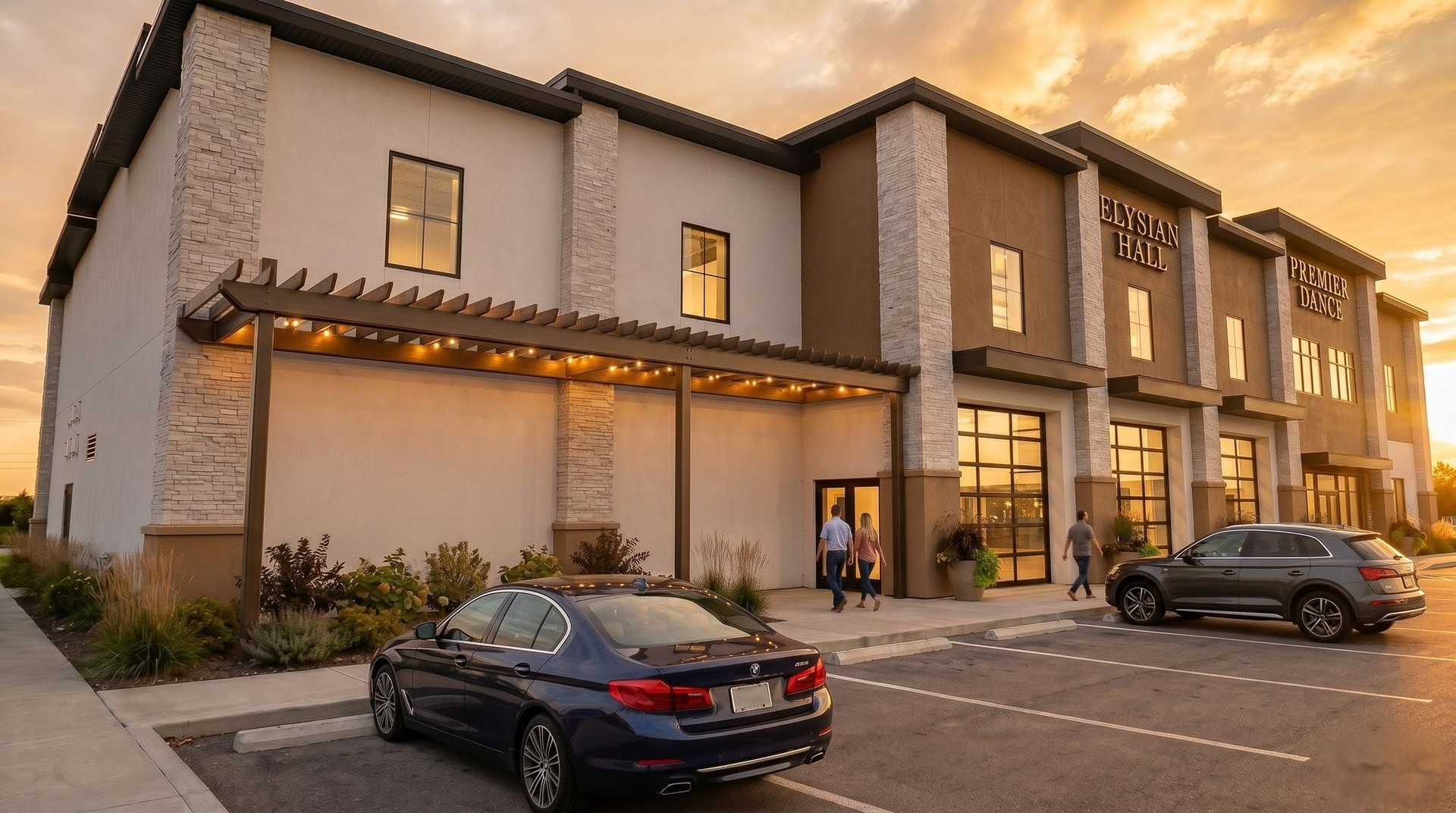 Artist rendering of the Elysian Hall exterior at golden hour, with stone columns, illuminated entrance, venue signage and parking in front