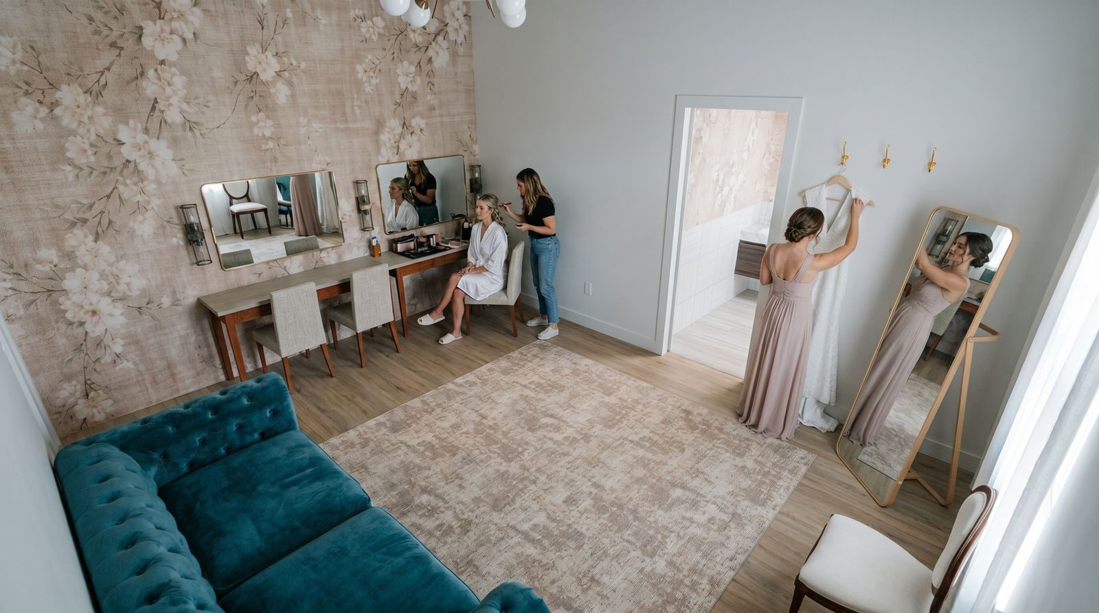 Artist rendering of a bride in the Bridal Suite with makeup mirrors, a full-length mirror, a teal sofa and a gown station